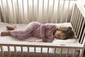 top view Cute little 3-4 years preschool baby girl kid sleeping sweetly in white crib during lunch rest time in pink Royalty Free Stock Photo