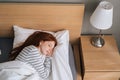Top view of cute redhead young woman sleeping well in bed hugging soft white blanket at home. Royalty Free Stock Photo