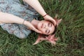 Top view of cute young attractive woman with colored hair in fashionable blue summer elegant dress on green grass on nature. Royalty Free Stock Photo