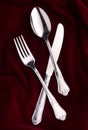 Top view cutlery covered in maroon cloth