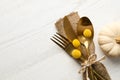 Top view cutlery decorated for autumn table setting and pumpkin on white wooden background, space for text