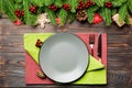 Top view of cutlery and plate on festive wooden background. New Year family dinner concept. Fir tree and Christmas decorations Royalty Free Stock Photo