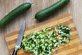 Top view of cutted fresh cucumbers on the wooden cutting board and knife