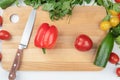 Top view of cutting board, kitchen knife and vegetables for salad. Royalty Free Stock Photo