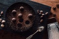 top view of cutting board with truffles on plate covering by grated chocolate anise, spoon, cocoa beans, nutmegs and grater Royalty Free Stock Photo