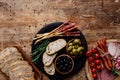 Top view of cutting boards with olives, breadsticks, prosciutto, salami, bread, tomatoes and herbs Royalty Free Stock Photo