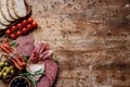 Top view of cutting boards with tasty salami, smoked sausages, olives, tomatoes and bread on wooden table Royalty Free Stock Photo