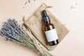 top view of dark glass dropper bottle vith lavender aromatic essential oil or extract on beige background. Bunch of scented dry Royalty Free Stock Photo