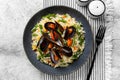 Top view of dark grey plate with hot mussels made with tomato and wine, rice and vegetables Royalty Free Stock Photo