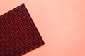 Top view of dark red rubber cutting mat on the left side over pink color paper background. Background with copy space Royalty Free Stock Photo