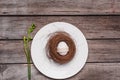 Top view of decorated Easter egg in nest on plate and spring plant on wooden table, Royalty Free Stock Photo