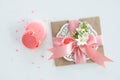 Top view of decorative kraft envelope with bow and pink macarons on white