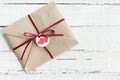 Top view of decorative kraft envelope with tag and ribbon on wooden tabletop