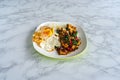 Top view of Deep fried crocodile meat stir fried with chilli and garlic with rice and fried egg in white plate on marble Royalty Free Stock Photo