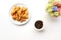 Top view of deep-fried dough stick with cold coffe and flower in