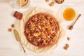 Top view of a delicious apple walnut cake with honey surrounded by ingredients on a white table Royalty Free Stock Photo