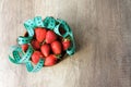 Top view of delicious big red strawberry in round wooden plate covered by measuring tape Royalty Free Stock Photo