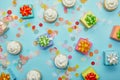 Top view of delicious cupcakes, confetti and gifts