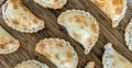 Delicious empanadas on wooden cutting board.