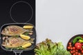 Top view of delicious fish with rosemary and lemon on grill and fresh vegetables Royalty Free Stock Photo