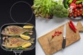 Top view of delicious fried fish on electric stove and fresh vegetables with wooden