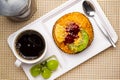 Top view of delicious homemade mixed fruit danish, a cup of black coffee, grapes and metal spoon in white plastic tray Royalty Free Stock Photo