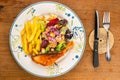 Top view of delicious homemade salmon steak with french fried and caesar salad in white ceramic plate Royalty Free Stock Photo