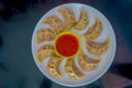 Top view of delicious Nepali traditional snack, chicken MoMo serve with spicy and sour sauce in a white plate