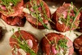 top view of delicious raw meat steak decorated with sprigs of rosemary