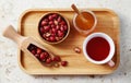 Delicious rose hip tea in cup with dried rose hips on wooden tray