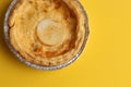 Top view of a delicious three cheese quiche on a yellow background