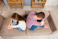 Top view of depresed man and woman sitting back to back on the sofa