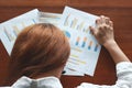 Top view of depressed business woman with charts or paper work bend down head on the desk