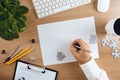 Top view of desktop with a businessman hand holding pen