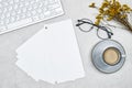 top view of desktop, Mockup of business cards stack with cup of milk coffee, eyeglasses and gypsophila and keyboard . Royalty Free Stock Photo
