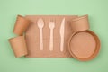 Top view on different eco-friendly tableware, kraft paper food packaging and wooden cutlery on green background. Street Royalty Free Stock Photo