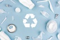 Top view of Different garbage materials with recycling symbol on blue background Royalty Free Stock Photo