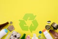 Top view of Different garbage materials with recycling symbol on yellow background. Recycle, World Environment Day and Eco concept Royalty Free Stock Photo