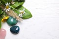 Top view of different gemstones and healing herbs on wooden table, space for text