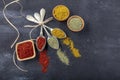 Top view of different kinds of colorful spices in spoons on black stone surface. Creative food concept texture with blank copy Royalty Free Stock Photo