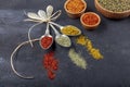 Top view of different kinds of colorful spices in spoons on black stone surface. Creative food concept texture with blank copy Royalty Free Stock Photo