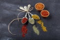 Top view of different kinds of colorful spices in spoons on black stone surface. Creative food concept texture with blank copy Royalty Free Stock Photo