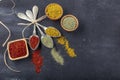 Top view of different kinds of colorful spices in spoons on black stone surface. Creative food concept texture with blank copy Royalty Free Stock Photo