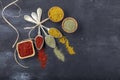 Top view of different kinds of colorful spices in spoons on black stone surface. Creative food concept texture with blank copy Royalty Free Stock Photo