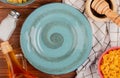 top view of different macaronis in bowls salt black pepper butter around plate on wooden background