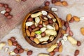 Top view of different nuts: almonds, pistachios, peanuts, hazelnuts in wooden bowl on light background. Royalty Free Stock Photo