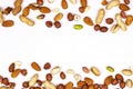 Top view of different nuts mix: almonds, pistachios, peanuts, hazelnuts as a horizontal frame isolated on white background.