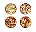 Top view of different nuts mix set: almonds, pistachios, peanuts, hazelnuts heap in round brown wooden bowl isolated on white