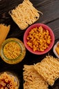 top view of different types of macaroni as bucatini cavatappi spaghetti vermicelli tagliatelle and others on wooden background