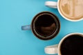 Top view of different typrs of hot coffe - black and with milk on a pastel blue background. Banner with copy space